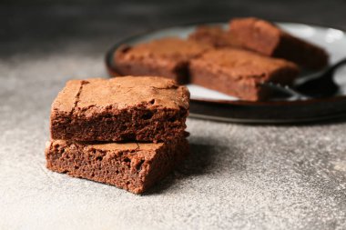 Gri arkaplanda lezzetli çikolatalı brownie parçaları