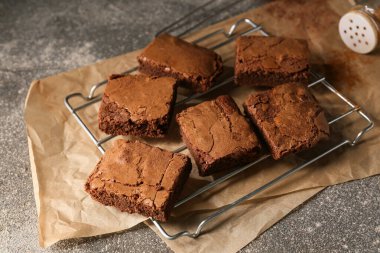 Gri arkaplanda lezzetli çikolatalı brownie parçaları olan bir şebeke.