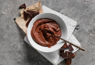 Gri arka planda çikolatalı kek hazırlamak için taze hamur kâsesi.