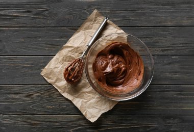 Koyu ahşap arka planda çikolatalı kek hazırlamak için taze hamur kâsesi.