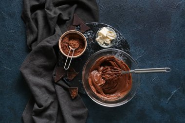 Siyah arka planda çikolatalı kek hazırlamak için taze hamur kâsesi.