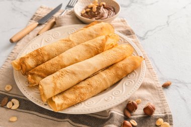 Masada çikolata ezmeli ve fındıklı bir tabak lezzetli krep.