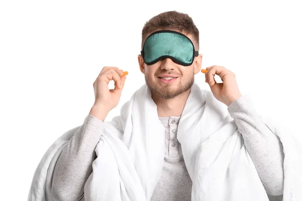 Young Man Sleeping Mask Blanket Putting Ear Plugs White Background — Stock fotografie