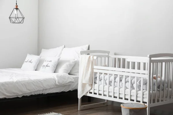 Beyaz Beşik Işık Duvarının Yanında Rahat Yatak — Stok fotoğraf