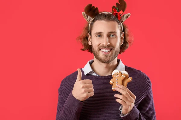 Handsome Man Deer Horns Gingerbread Cookies Showing Thumb Red Background — Stock Photo, Image