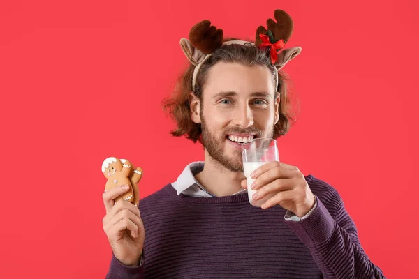 Handsome Man Deer Horns Gingerbread Cookies Drinking Milk Red Background — Stock Photo, Image