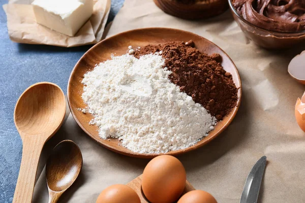 テーブルの上にチョコレートブラウニーを準備するための小麦粉とココアパウダーとプレート — ストック写真