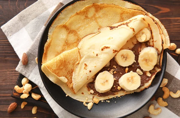 Plate Tasty Thin Pancakes Chocolate Paste Cut Banana Nuts Table — Foto de Stock