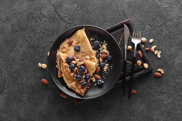 Plate Tasty Thin Pancakes Chocolate Paste Blueberries Nuts Black Background — Foto de Stock