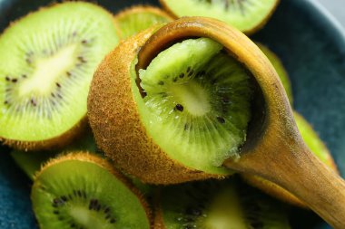 Fresh cut kiwi with spoon on table, closeup