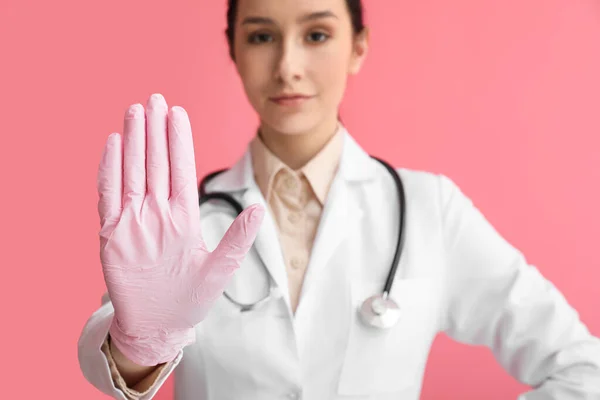 女性医師ショーストップジェスチャー上のピンクの背景 — ストック写真