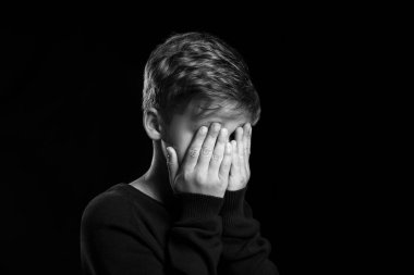 Siyah arka planda ağlayan küçük çocuk