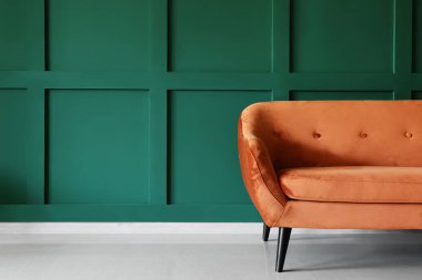 Yeşil duvarın yanında rahat kırmızı kanepe