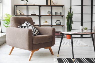 Oturma odasının iç tarafında rahat bir koltuk ve masa.