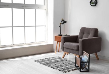 Rahat bir sandalye ve ışık odasındaki duvarın yanındaki masa.