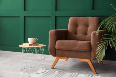 Renkli duvarın yanında rahat koltuk ve masa.