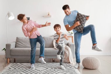 Mutlu adam ve çocukları evde dans ediyor.