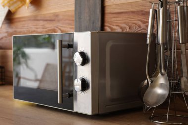 Mutfaktaki ahşap masa üstünde mikrodalga fırın.