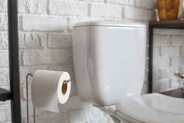 Tuvalette tuvalet kağıdı rulosu olan tutucu.
