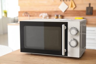 Mutfaktaki ahşap masa üstünde mikrodalga fırın.