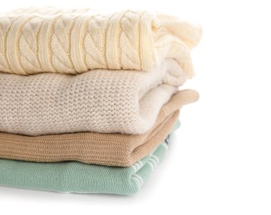 Beyaz arka planda şık bebek kazakları, yakın plan.