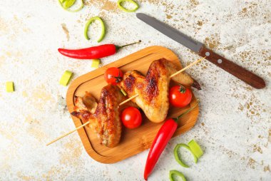 Ahşap tahta tahta, ızgara tavuk kanadı domatesli şiş.