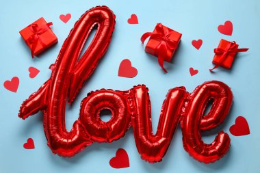 Mavi zemin üzerinde aşk kelimesi şeklinde balon olan kompozisyon. Sevgililer Günü kutlaması