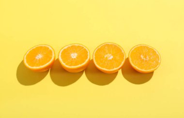 Sarı arkaplanda taze kesilmiş portakallar