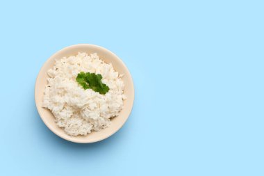 Mavi arka planda lezzetli haşlanmış pirinç kasesi.