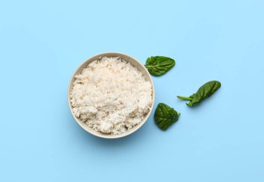 Lezzetli haşlanmış pirinç ve mavi arka planda ıspanak.