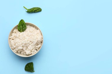 Lezzetli haşlanmış pirinç ve mavi arka planda ıspanak.