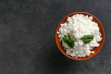 Koyu arkaplanda lezzetli haşlanmış pirinç kasesi.