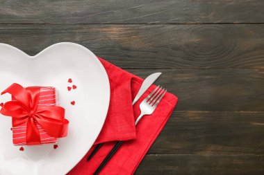 Karanlık ahşap arka planda Sevgililer Günü için güzel bir masa ve hediye.