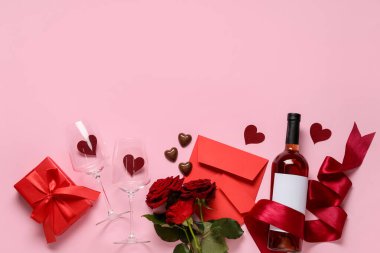 Pembe arka planda Sevgililer Günü için şarap, gül ve çikolata içeren kompozisyon