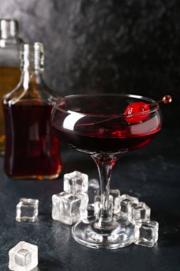 Siyah arka planda bir bardak Manhattan kokteyli.