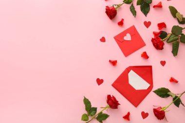 Zarflı kompozisyon ve pembe arka planda gül çiçekleri. Sevgililer Günü kutlaması