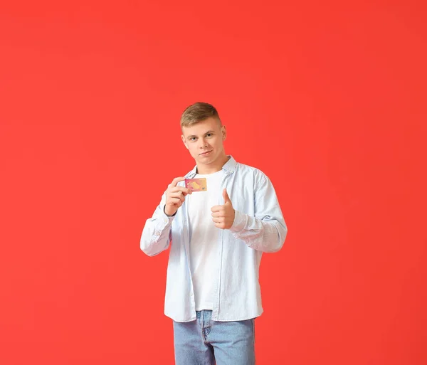 Handsome Young Man Credit Card Showing Thumb Red Background — Stock Photo, Image