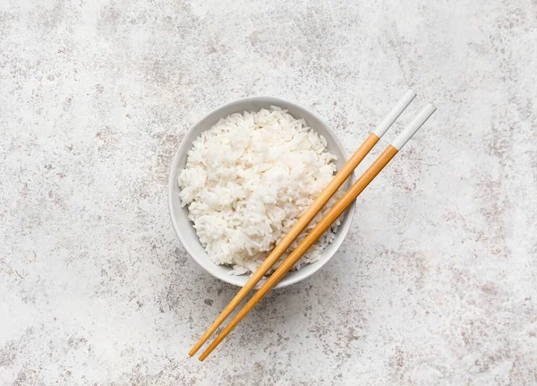 Cuenco Con Sabroso Arroz Hervido Palillos Sobre Fondo Claro — Foto de Stock