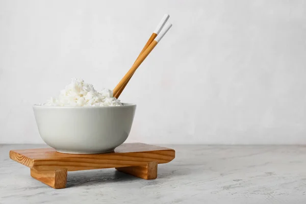 Cuenco Con Sabroso Arroz Hervido Palillos Sobre Fondo Claro —  Fotos de Stock