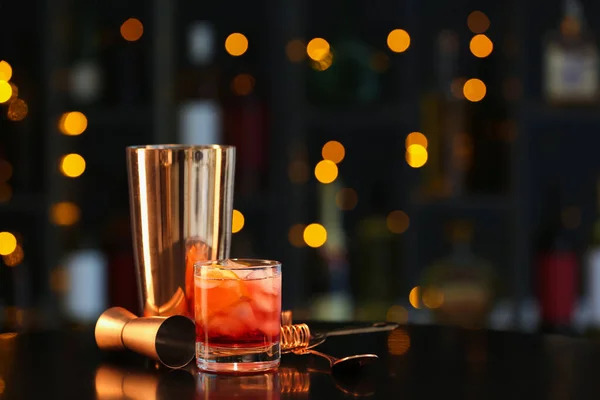 Glas Smakelijke Negroni Cocktail Maatbeker Shaker Tafel Tegen Wazige Achtergrond — Stockfoto