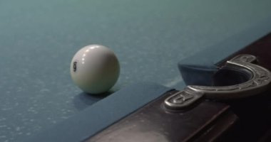 Top bilardo masasının cebine düştü, yakın plan.