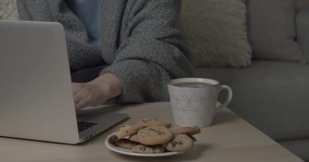 Ung Kvinna Dricker Varmt Kaffe När Använder Laptop Hemma — Stockvideo