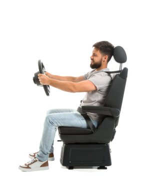 Beyaz arka planda araba koltuğunda direksiyon sallayan yakışıklı adam.