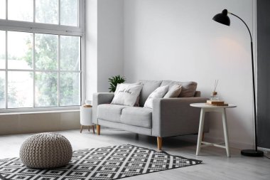 Masası, kanepesi ve puf olan ışık odasının içinde.