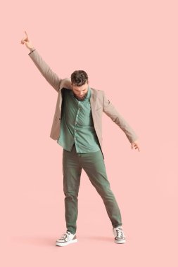 Renkli arka planda havalı dans eden genç adam.