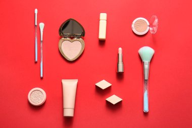 Kırmızı arkaplanda dekoratif kozmetik ürünler