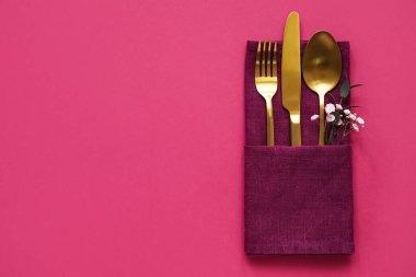 Pembe arka planda şık çatal bıçak takımı