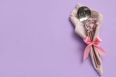 Mor arkaplanda şık çatal bıçak takımı