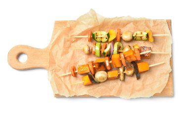 Beyaz arka planda lezzetli sebze şişleri olan tahta