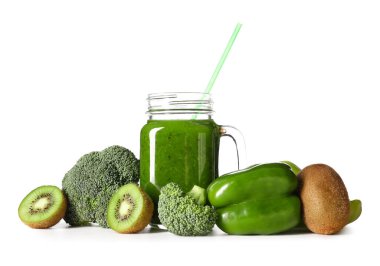 Mason kavanozu dolusu sağlıklı yeşil meyve suyu ve beyaz arka planda taze malzemeler.